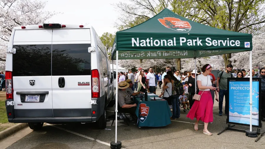 Washington D.C, U.S.A - March 29, 2025 - The National Park Service information booth, staffed by a park rangers, assists visitors during the Cherry Blossom Festival