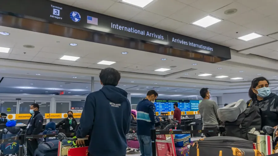 airline arriving passengers waiting in line for their mandatory covid