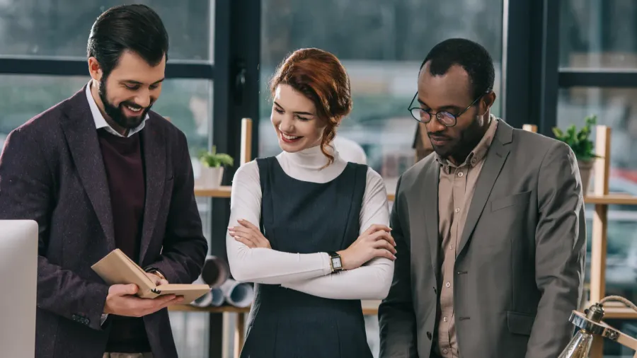 multiethnic architects discussing work in modern office